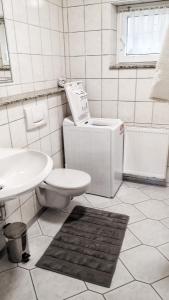 a white bathroom with a toilet and a sink at 2-Zimmer Ferienwohnung, MONTEURZIMMER! 20 min zum CGN Flughafen. in Lohmar