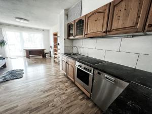 a kitchen with wooden cabinets and a stove top oven at 2-Zimmer Ferienwohnung, MONTEURZIMMER! 20 min zum CGN Flughafen. in Lohmar