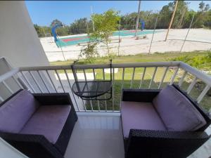 einen Balkon mit zwei lila Sofas und einem Spielplatz in der Unterkunft Centric and cozy apartment in Punta Cana