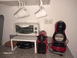 eine Küche mit einem Toaster, einem Backofen und einem Stuhl daneben in der Unterkunft Centric and cozy apartment in Punta Cana