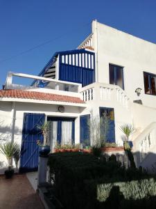 ein weißes Haus mit blauen Fenstern und Pflanzen in der Unterkunft Bel appartement à Oualidia in Oualidia