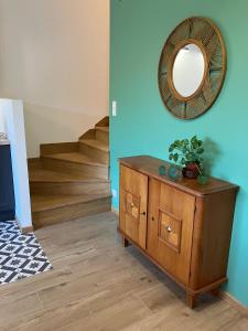 um quarto com uma cómoda de madeira e um espelho em Superbe logement "Loulaloue" ! em Ornans