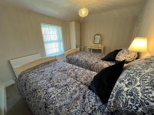 a bedroom with two beds and a window at Limes Cottage in Cowbridge