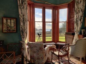 a living room with a large window with a view at Torloisk House in Kilninian