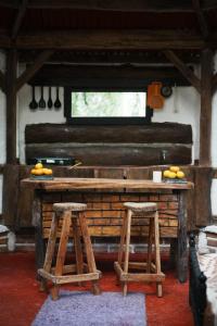 a kitchen with two stools and a table with oranges on it at Bosque de Oro in Apía