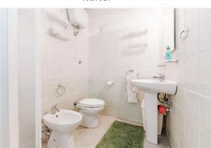 bagno bianco con servizi igienici e lavandino di Casa vacanze Cagliari Poetto a Quartu SantʼElena