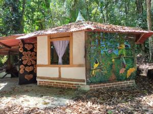 une petite maison avec une fenêtre et un tableau. dans l'établissement Bosque de Oro, à Apía