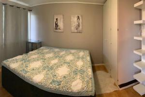 a bedroom with a bed and two pictures on the wall at Velkommen til en koselig leilighet på Sørlandet! in Kristiansand