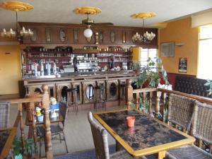 a restaurant with a table and a bar at Le Soleil D'or in Vimoutiers