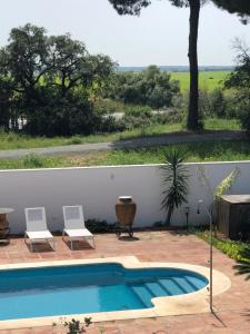 a small swimming pool with two chairs next to a fence at Juliana 3 home in Seville