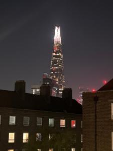 a tall building lit up in the sky at night at The Mount in London