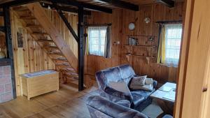 a living room with a couch and stairs in a cabin at Domek wypoczynkowy Gowidlino in Gowidlino