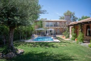 a house with a swimming pool in a yard at Posada Boutique El Encuentro Chacras de Coria in Chacras de Coria