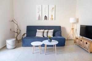 a living room with a blue couch and a table at Ki.Kos - Private House in Kos