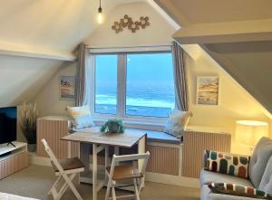 sala de estar con mesa y ventana grande en Pier View Retreat - Close to Beach - Sea Views With Parking, en Bournemouth