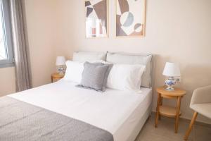 a bedroom with a white bed with white pillows at Ki.Kos - Private House in Kos