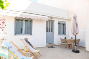a patio with chairs and a table and an umbrella at Ki.Kos - Private House in Kos