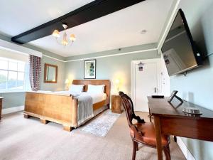 Colthrop Manor B&B في ثاتشام: غرفة نوم مع سرير ومكتب
