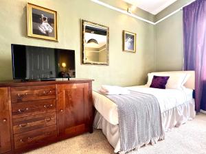 1 dormitorio con 2 camas, TV y tocador en Colthrop Manor B&B en Thatcham