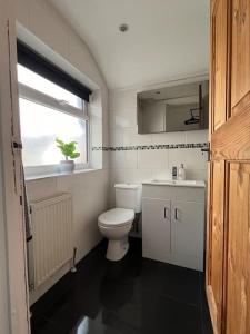 een badkamer met een toilet, een wastafel en een raam bij Entire house in Liverpool in Litherland