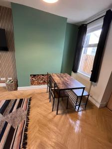 a dining room with a wooden table and chairs at Entire house in Liverpool in Litherland