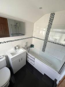 een badkamer met een toilet, een wastafel en een bad bij Entire house in Liverpool in Litherland