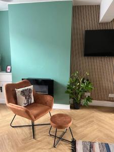 a living room with a chair and a tv at Entire house in Liverpool in Litherland