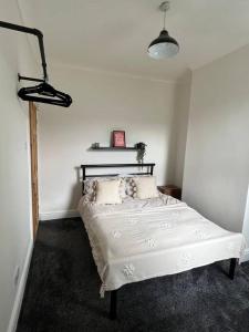 a bedroom with a white bed with two pillows at Entire house in Liverpool in Litherland