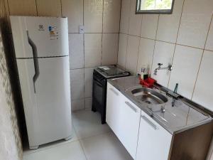 a small kitchen with a sink and a refrigerator at Casa em Lavras Novas in Ouro Preto
