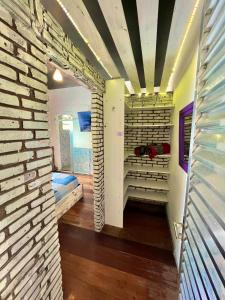 a walk in closet with a brick wall at Suíte Explorer in Praia Grande