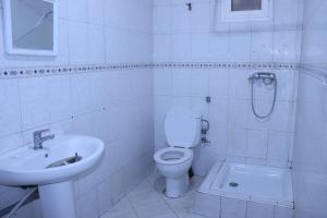 een witte badkamer met een toilet en een wastafel bij YOUR HOUSE in Rabat