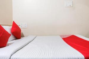 - une chambre avec un lit et des oreillers rouges dans l'établissement OYO Flagship Maheshwari Villas, à Chennai