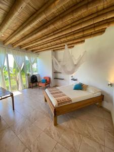 1 dormitorio con 1 cama con una red colgada del techo en Casa Cosmonova en Puerto López