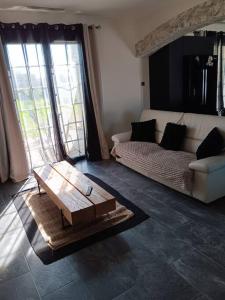 sala de estar con sofá y mesa de centro en La villa des jonquilles spa détente en Saint-Victor