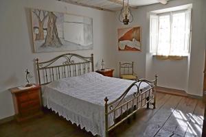 1 dormitorio con cama blanca y ventana en La casa del Berlingaio, en Stazzema