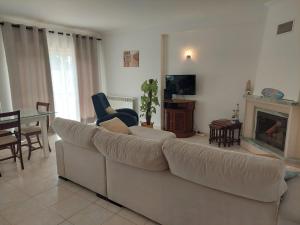 uma sala de estar com um sofá branco e uma mesa em Casa Moderna em Atouguia da Baleia