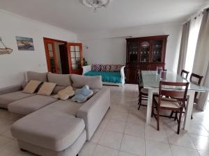 uma sala de estar com um sofá e uma mesa em Casa Moderna em Atouguia da Baleia