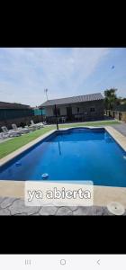 a large blue swimming pool in front of a building at Chalet con piscina en escalona in Toledo