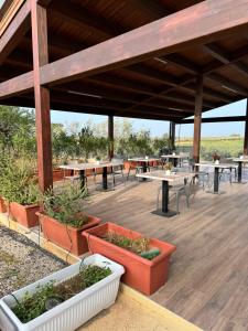 a pavilion with tables and potted plants on a wooden deck at Baglio Eldama in Castelvetrano Selinunte