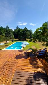 a deck with a pool and two chairs and a table at Quinta Cáceres in Santa Ana