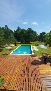 a swimming pool on a wooden deck with two umbrellas at Quinta Cáceres in Santa Ana