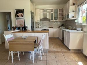 een keuken met witte kasten en een tafel en stoelen bij Primavera Retreat in Chania