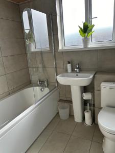 ein Badezimmer mit einem Waschbecken, einer Badewanne und einem WC in der Unterkunft Mountcollyer #3 in Belfast