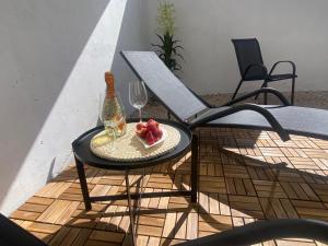 una mesa con una copa de vino y un plato de fruta en Apartments Dante Domus Aurea, en Milna
