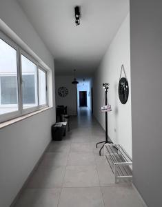 um quarto com um corredor com paredes brancas e uma janela em Zenia Court em Marsaskala