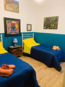 two beds in a room with blue and yellow at Casa Franca a Marzamemi in Marzamemi