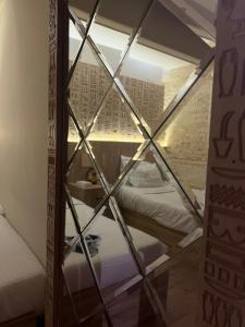 una camera con una finestra di vetro e un letto. di Pyramids Top guest house a Il Cairo