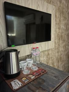 un tavolo con tv e alcune tazze e acqua di Pyramids Top guest house a Il Cairo