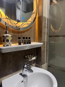 un bagno con un lavandino bianco e uno specchio di Pyramids Top guest house a Il Cairo Altre 30 foto