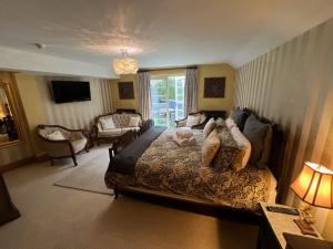 a bedroom with a large bed and a living room at The Bridge House Restaurant and Hotel in Alton
